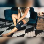 Naine paigaldab Compex ComfortTENS Knee tugisideme põlvele ja kinnitab takjakinnitused