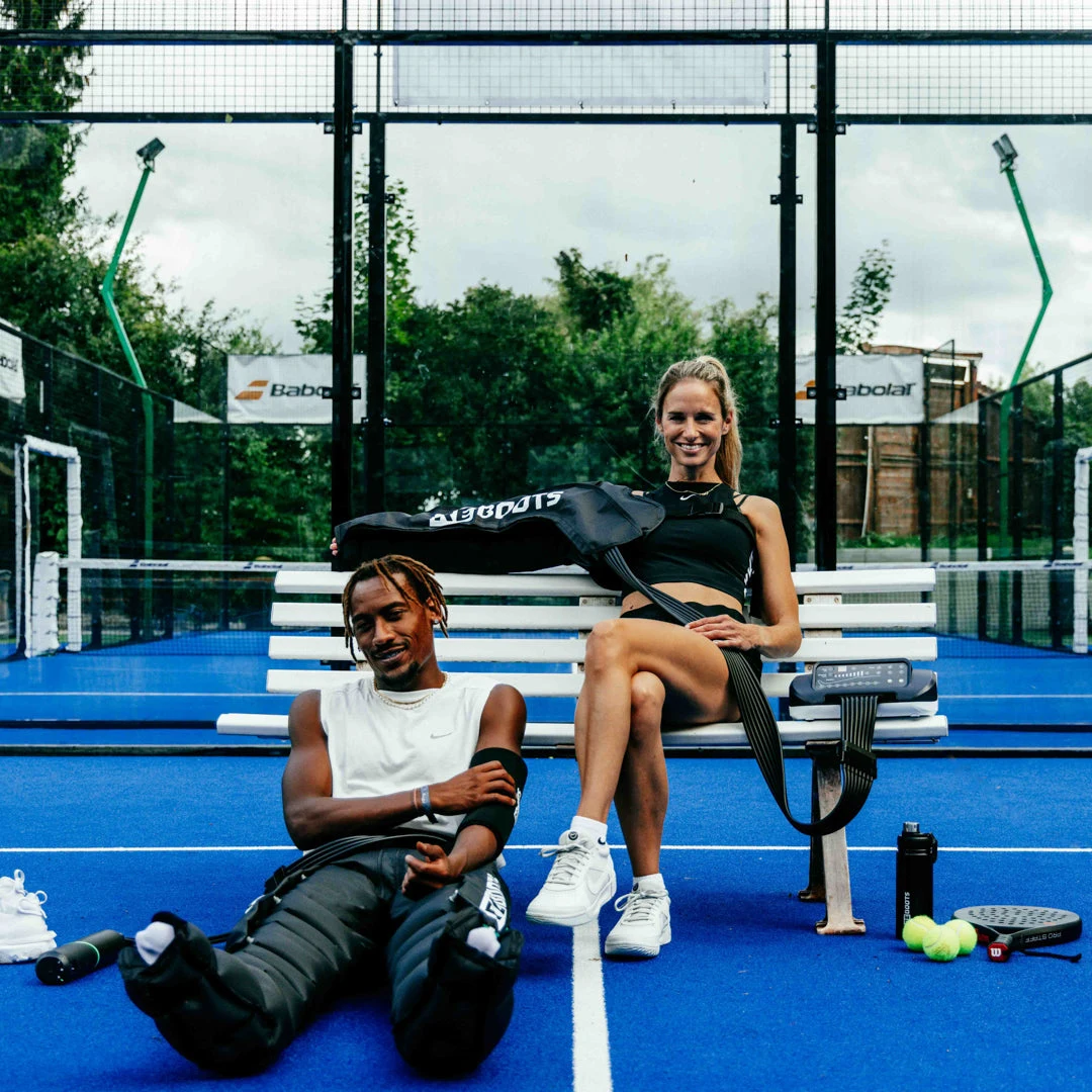 Kaks sportlast kasutavad Reboots käemansette ja kompressioonipükse padelväljakul